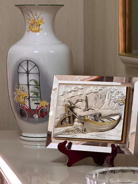 a table with a picture and a vase on it at ALFA Holidays in Sorrento