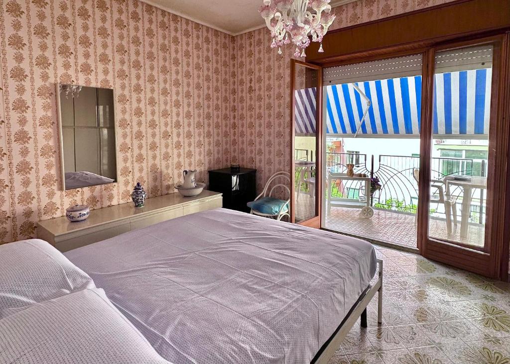 Un dormitorio con una cama y una ventana grande. en ALFA Holidays, en Sorrento