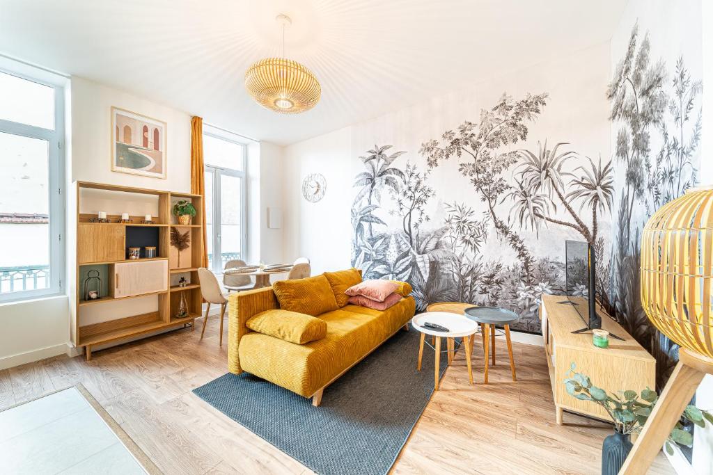 un salon avec un canapé jaune et une table dans l'établissement Le Marietton appartement cosy à deux pas du métro Valmy, à Lyon