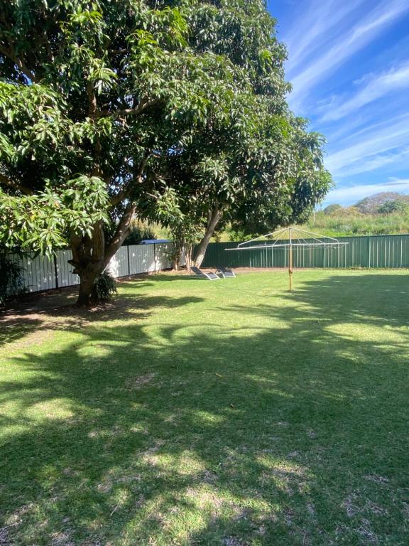 a large yard with trees and a fence at Beachmere Palms Motel in Beachmere