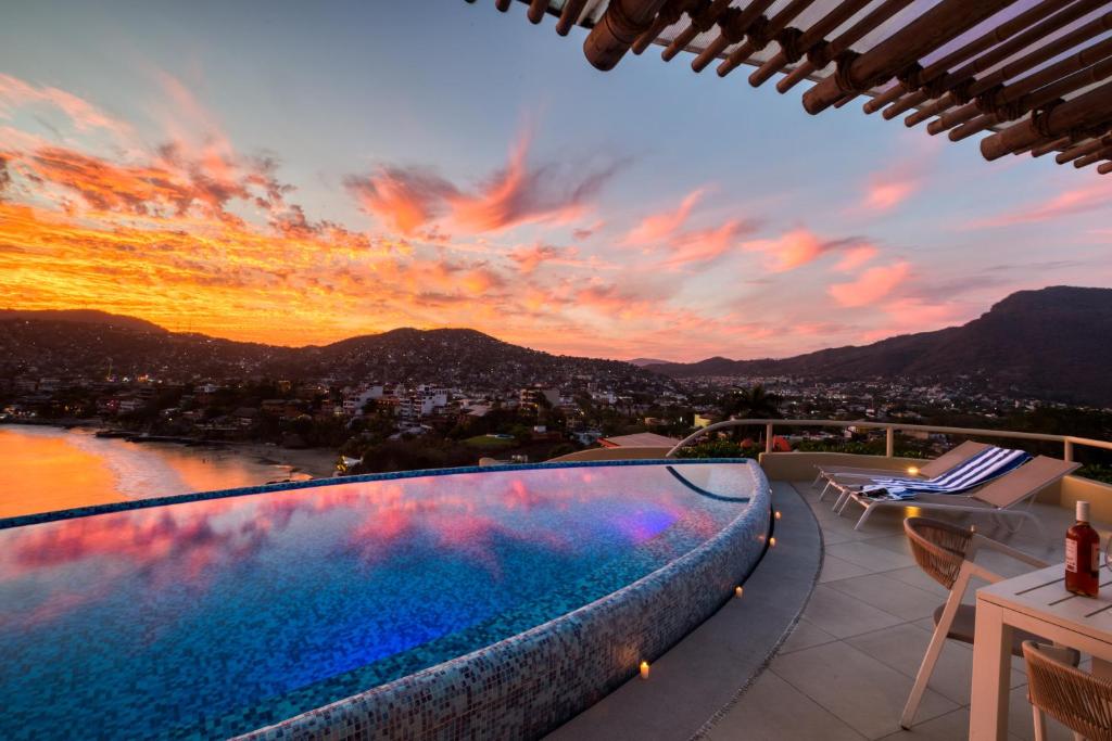 a pool on the roof of a house with a sunset at Villas Kaukan by Tasman in Zihuatanejo
