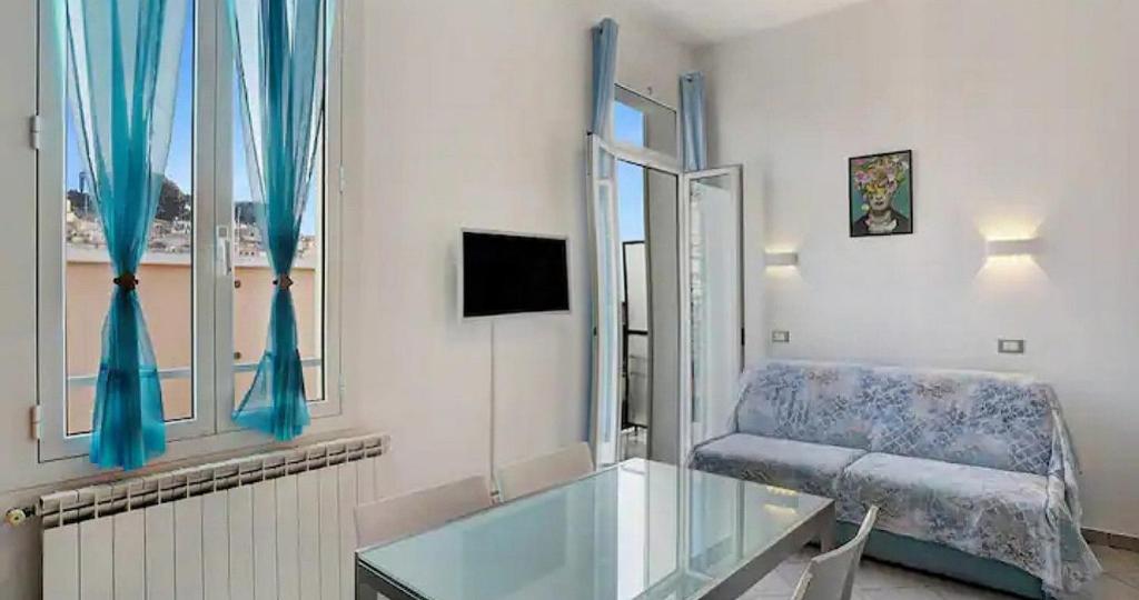 Una sala de estar con una mesa de cristal y un sofá. en Frida apartments, en San Remo