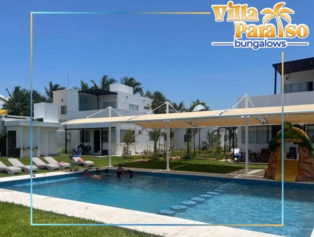 La ViguetaにあるBungalows Villa Paraísoの建物の前にスイミングプールがあるヴィラ