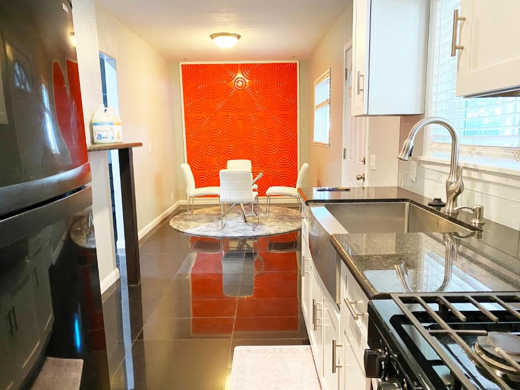 a kitchen with two white chairs and a red wall at Chic Victorian Oasis - Oakland Heart in Oakland