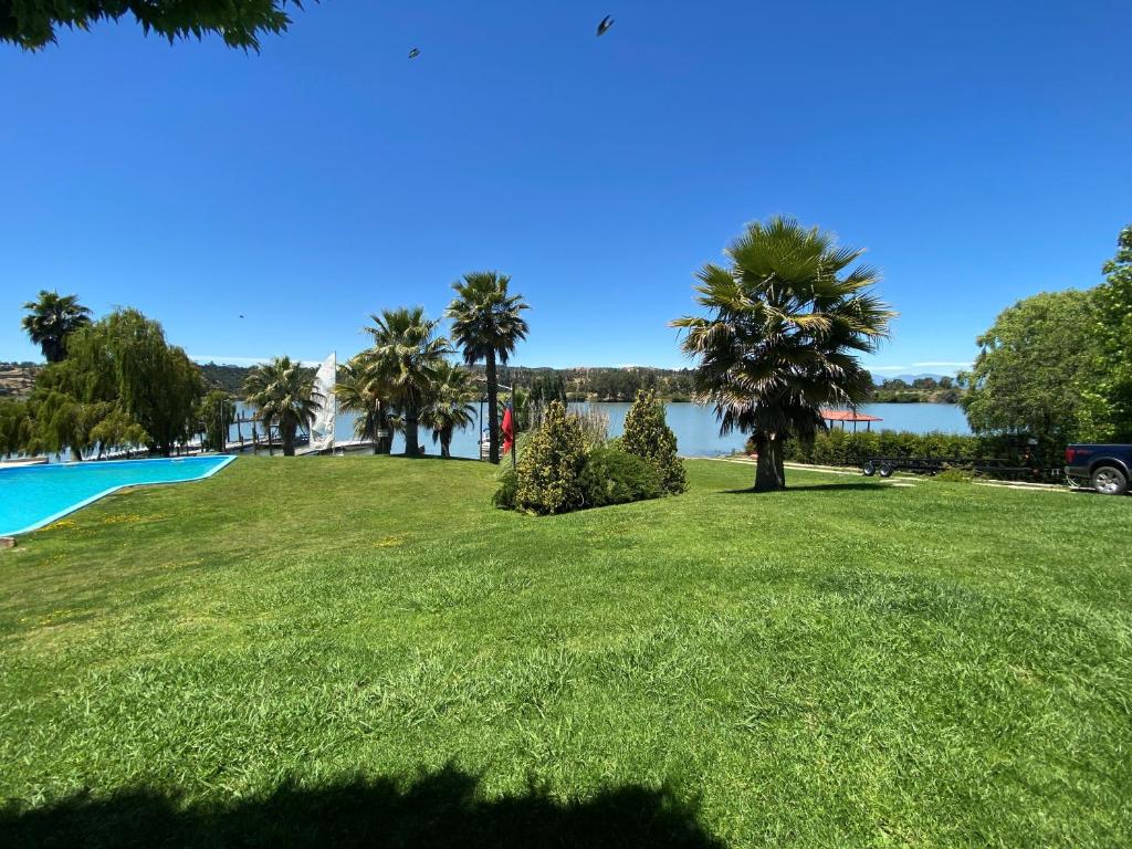 un parc avec des palmiers et une étendue d'eau dans l'établissement Costa del Sol de Rapel, à La Estrella