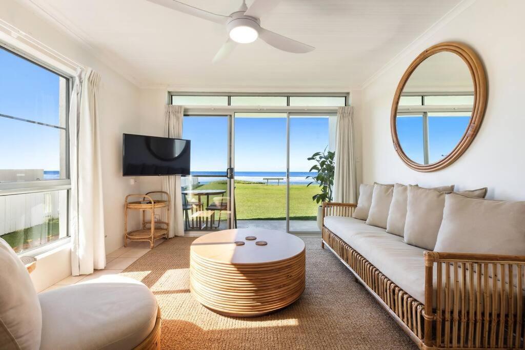 a living room with a couch and a table at Absolute Beachfront Apartment 11B in Lennox Head