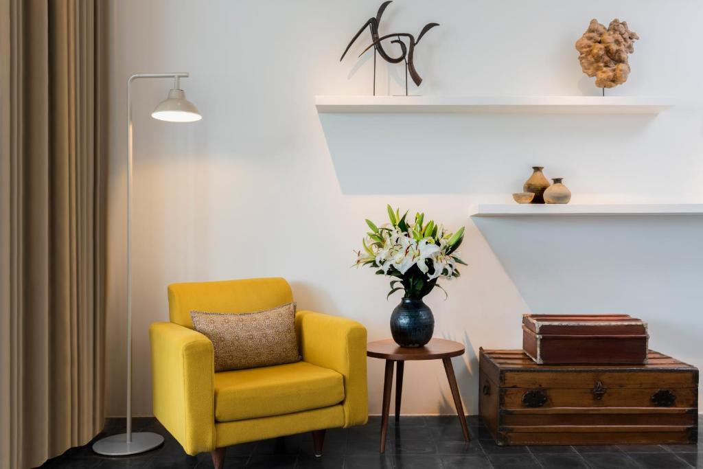 a yellow chair and a vase of flowers in a room at Viroth's Hotel in Siem Reap