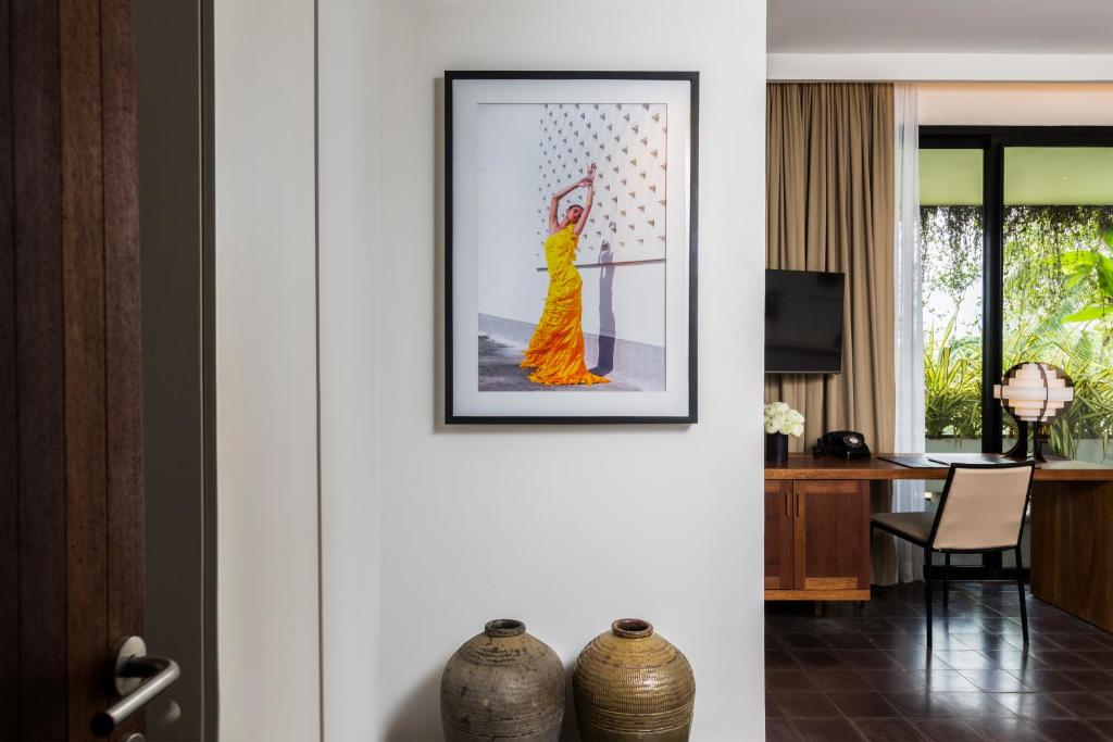 a picture of a woman in a yellow dress on a wall at Viroth's Hotel in Siem Reap