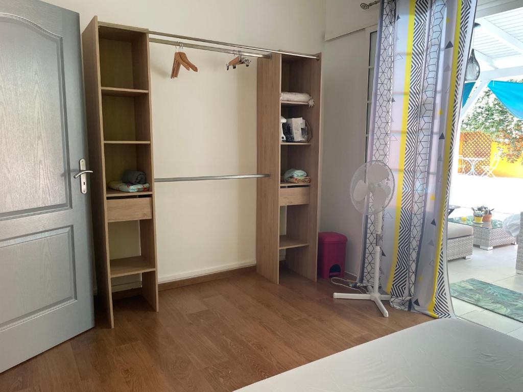 Habitación con armario, nevera y puerta. en Sarithea, en Basse-Terre