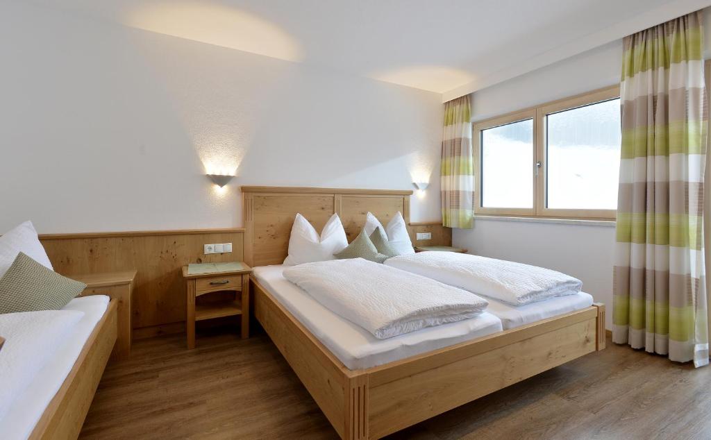 a bedroom with a large bed and a window at Apart Geisler in Mayrhofen