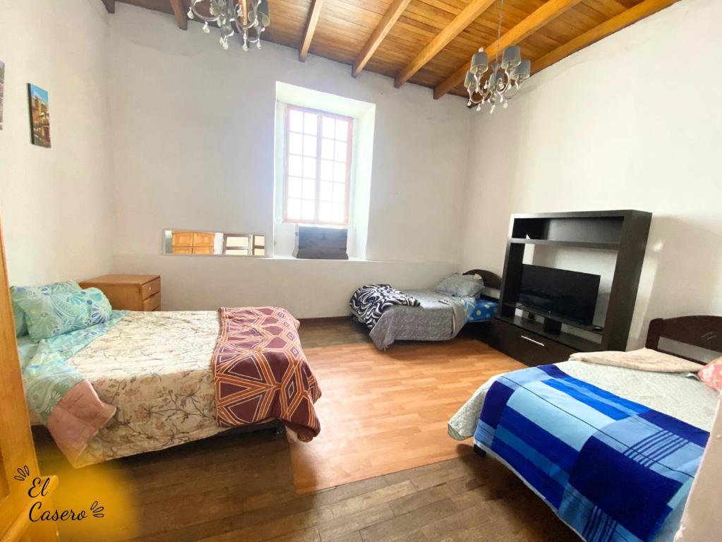 a bedroom with two beds and a flat screen tv at MiniDepa Centrico in Cajamarca