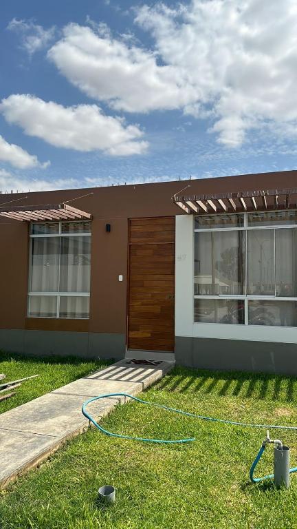 a house with a hose in the grass in front of it at Rincon del Relax in Viña Abajo