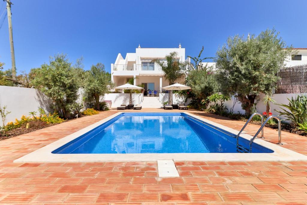 a swimming pool in front of a house at Villa Fuseta 102 T in Fuzeta