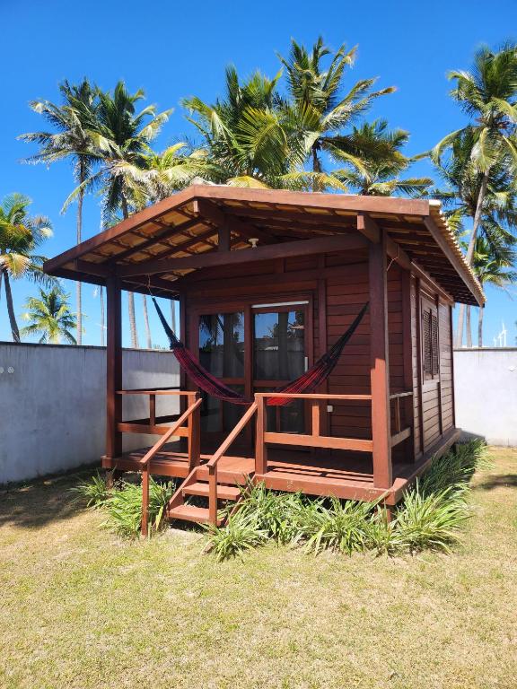 eine kleine Hütte mit einer Hängematte im Gras in der Unterkunft Vila do Rico in São Gonçalo do Amarante