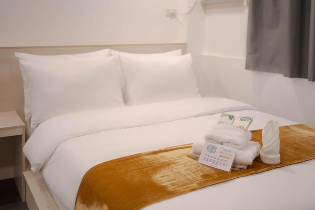 a bed with a tray with two towels on it at A Traveller&#39;s Inn in Daraga