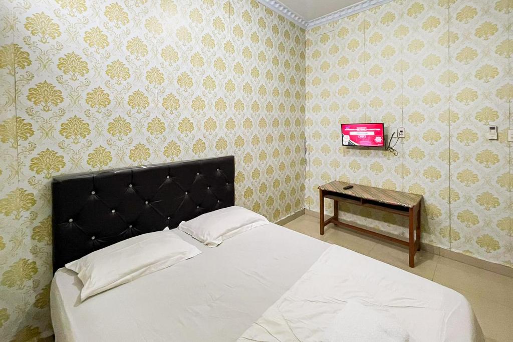 Ένα ή περισσότερα κρεβάτια σε δωμάτιο στο Homestay Rand's Kopi Pandan Syariah Mitra RedDoorz