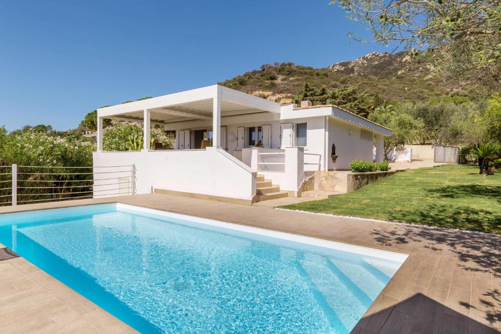 une villa avec piscine devant une maison dans l'établissement Villa Angelina con piscina e giardino privato a pochi passi dalla Spiaggia di Campus, à Villasimius