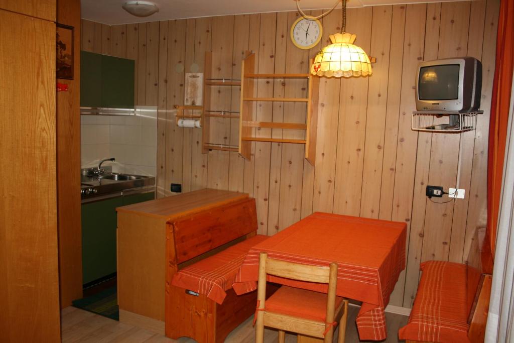 eine Küche mit einem Tisch und einem TV in einem Zimmer in der Unterkunft Appartamento Amba 39 in Mezzana