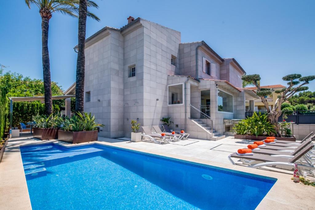 a pool in front of a house with palm trees at Ideal Property Mallorca - Barcares Nou in Alcudia