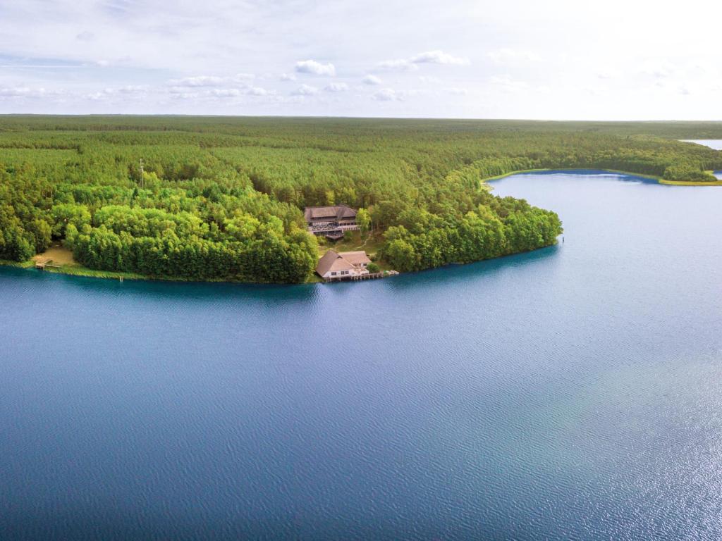 eine Insel inmitten eines Sees mit einem Haus in der Unterkunft Van der Valk Naturresort Drewitz in Nossentiner Hütte