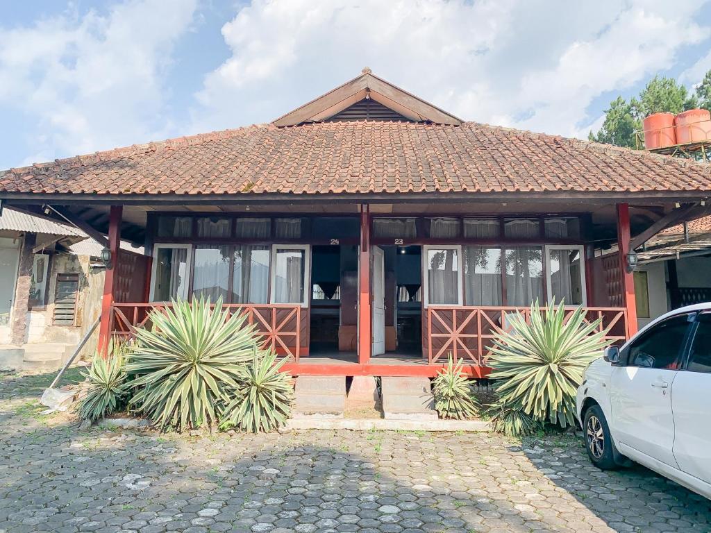 a house with a pavilion with a car parked in front at Pesona Pondok Lembang Mitra RedDoorz in Cikidang 1