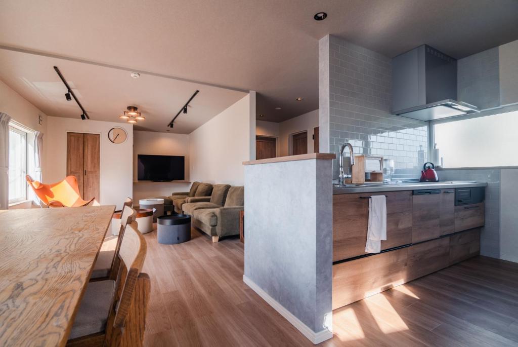 a kitchen and living room with a counter and a table at 5分車程札幌中心大通公園 豐平川河景四房 廁所x2 浴室x1 淋浴x1 包棟別墅近地鐵 停兩台車 in Sapporo