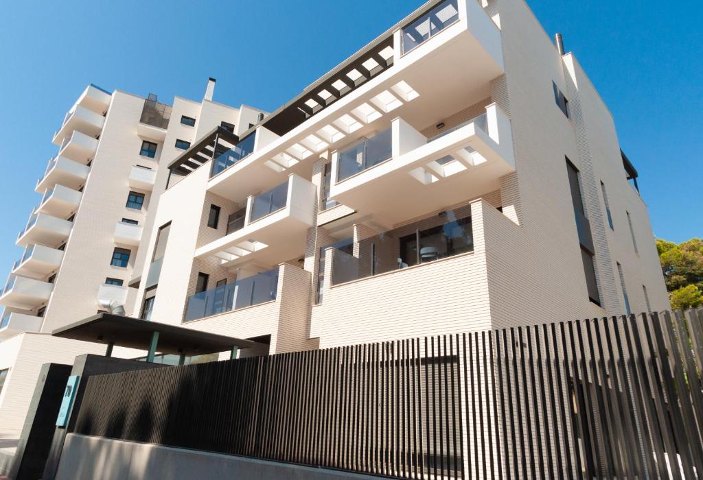 a white building with a fence in front of it at Myflats Campello Beach in El Campello
