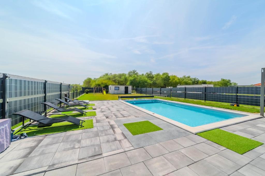 a swimming pool with chairs and a fence at Wellness Villa Joy near Varaždin - Happy Rentals in Sračinec