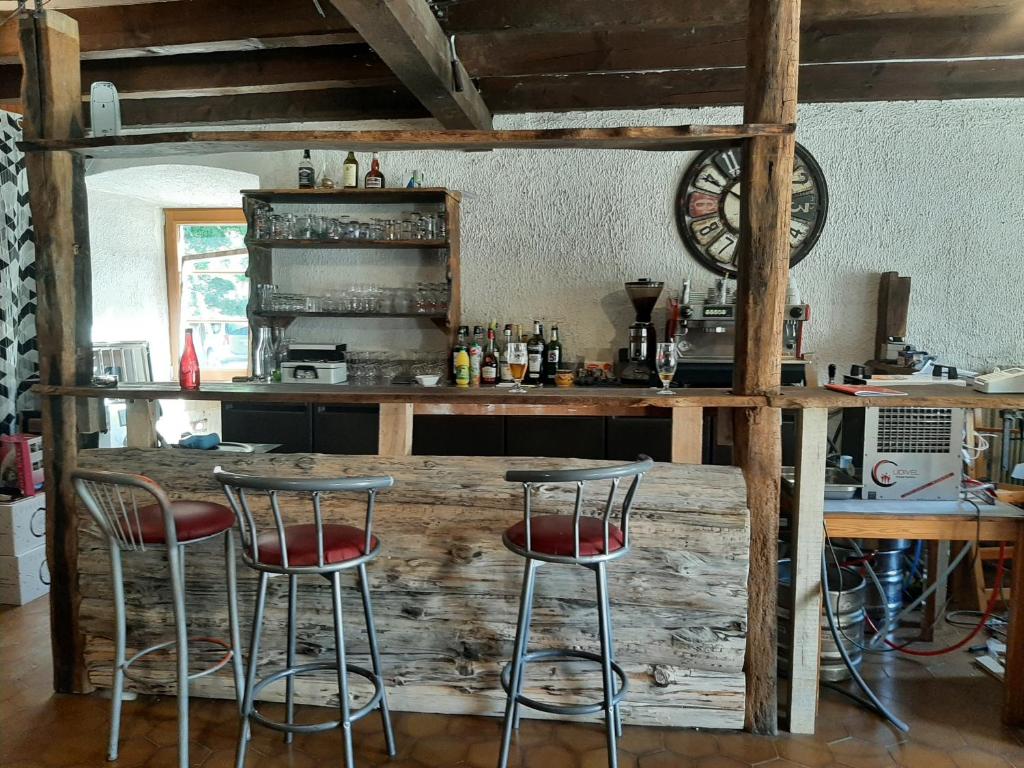 a kitchen with a wooden bar with two stools at la chaumière des barthes in Laussonne
