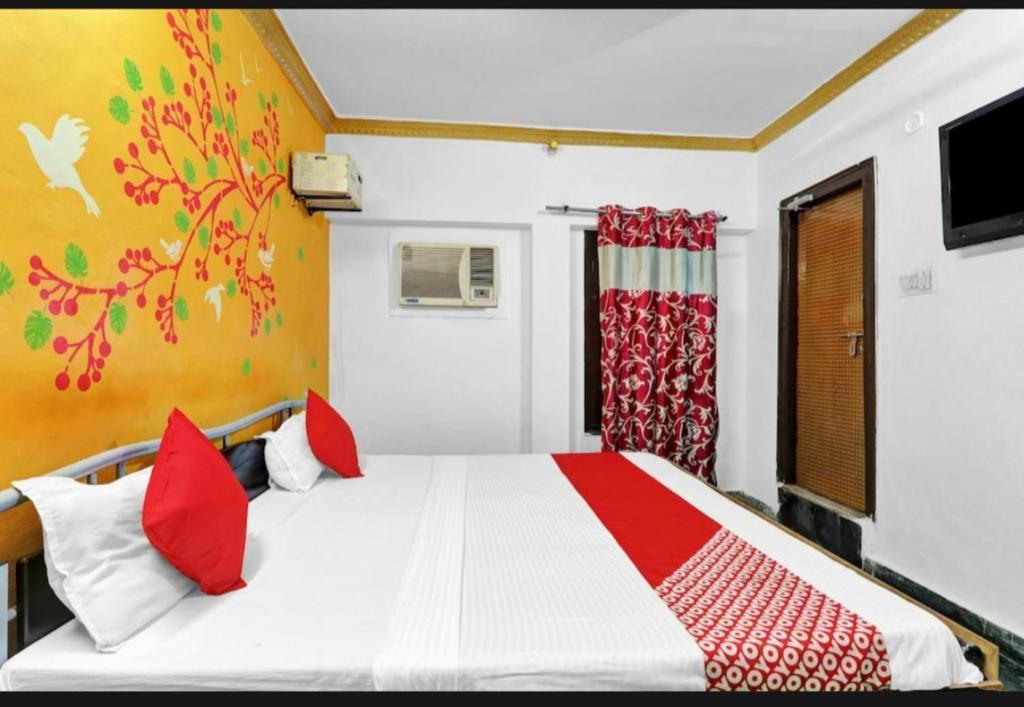 a bedroom with a white bed with red pillows at Best hotel in Lucknow