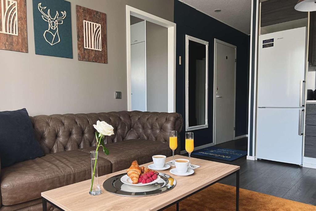 a living room with a couch and a table with food at Hotel Golden Circle Suites in Rovaniemi