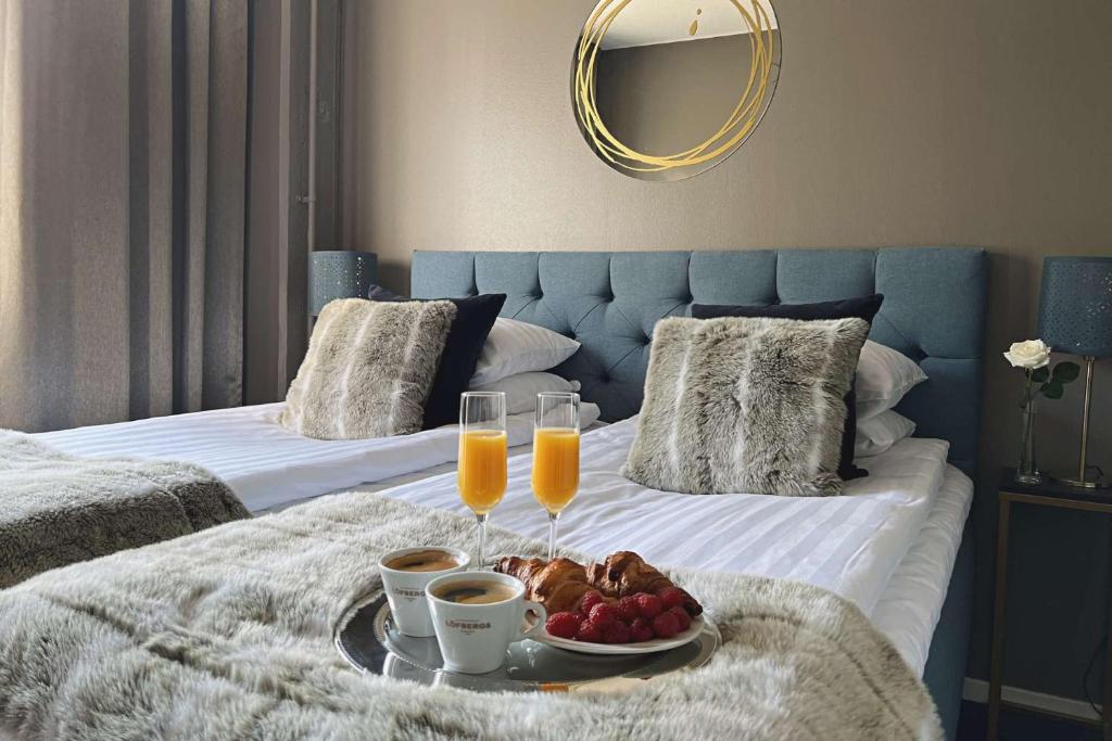a tray of food on a bed with two beds at Hotel Golden Circle Suites in Rovaniemi