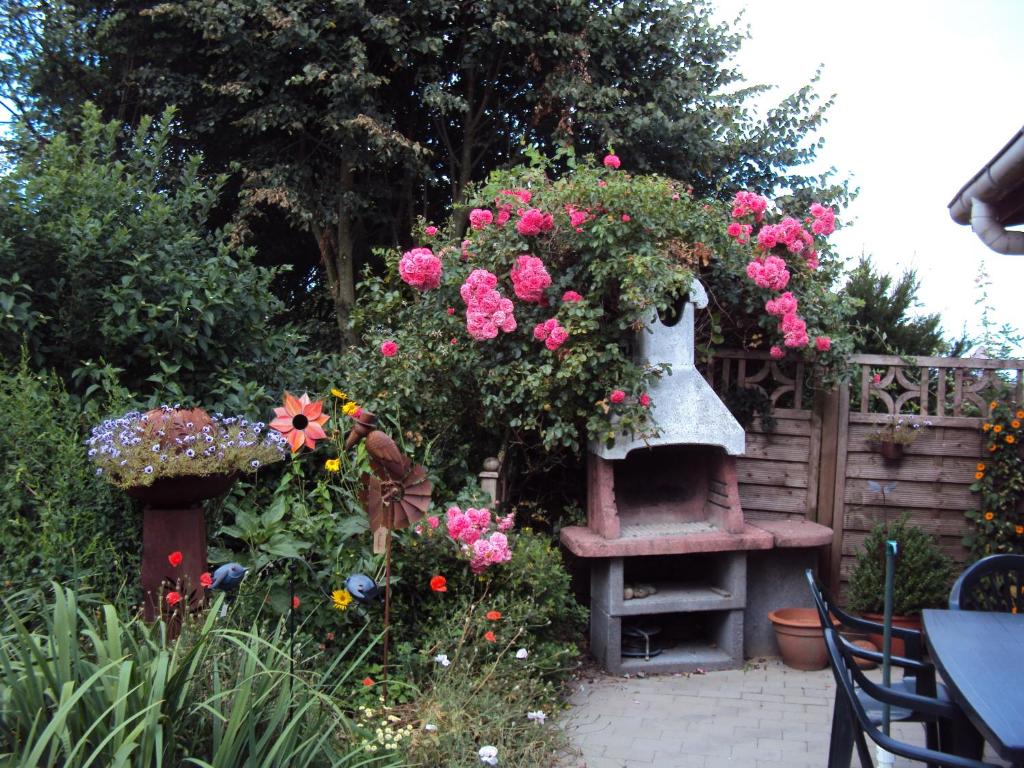 a garden with pink flowers and a bird feeder at Haus Denker in Brunsbüttel