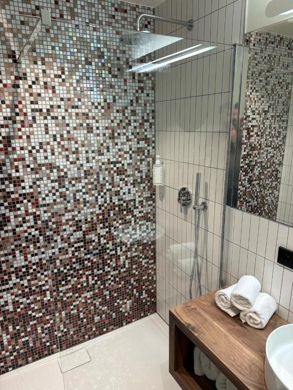 a bathroom with a glass shower with a sink and a shower at La Différence in Vichten