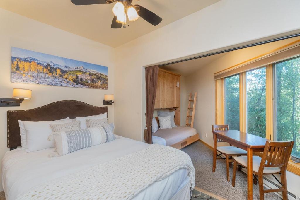 a bedroom with a bed and a desk and a table at Charming Studio w Kitchenette, Hot Tub Near River condo in Telluride
