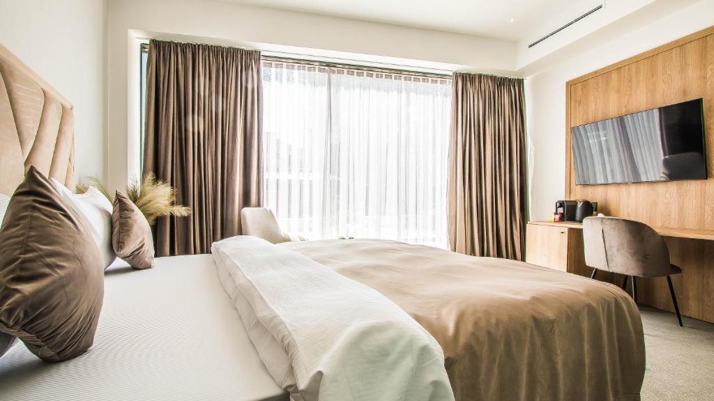 ein Hotelzimmer mit einem Bett und einem großen Fenster in der Unterkunft Central Apart Hotel in Bukarest