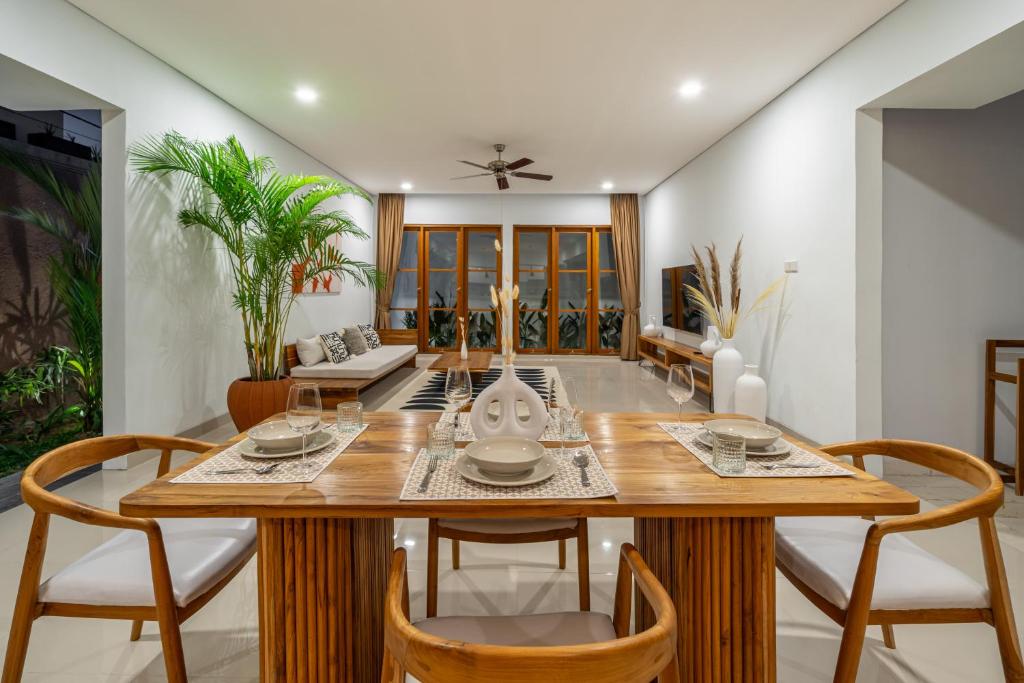 a dining room with a wooden table and chairs at Stunning 2BDR Villa with Private Pool in CANGGU in Canggu
