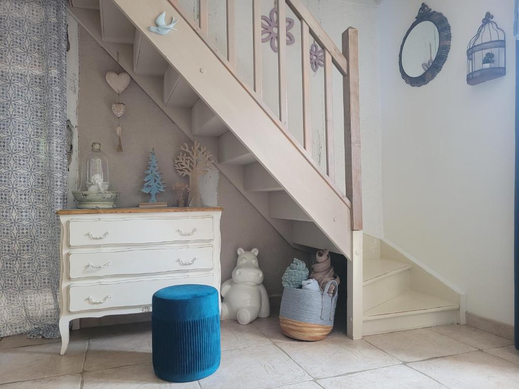 Ein Zimmer mit einer Treppe, einer Kommode und einem blauen Hocker in der Unterkunft Maison féérique et ludique, avec jeux de piste in Saint-Romain-le-Preux