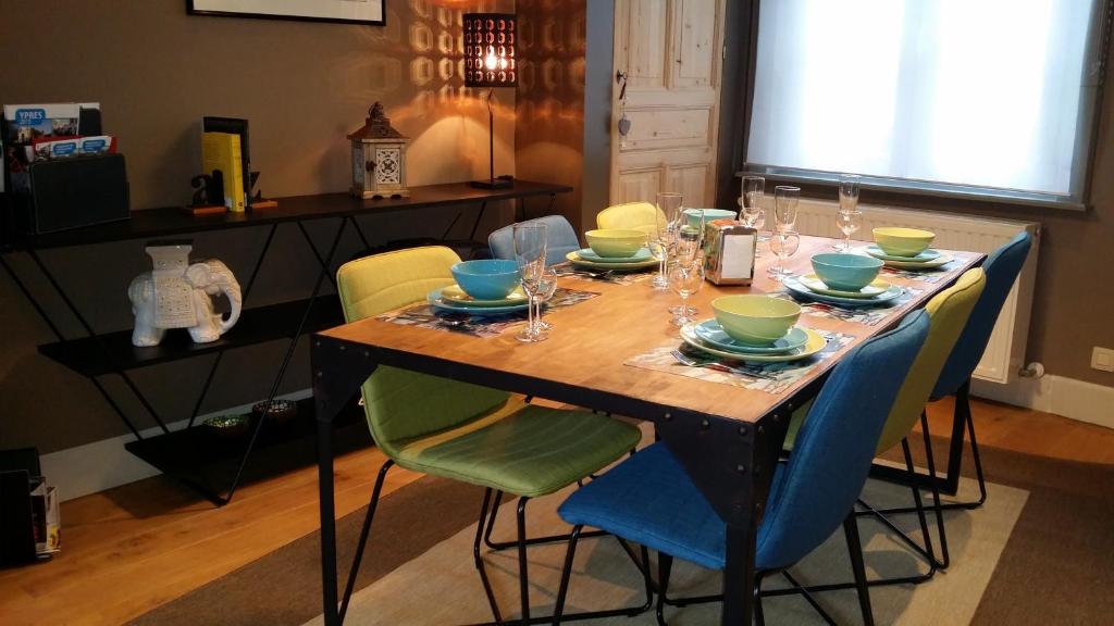 una mesa de comedor con sillas, platos y vasos. en Ypres Ramparts House, en Ypres