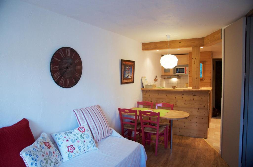 ein Wohnzimmer mit einem Tisch und einer Uhr an der Wand in der Unterkunft Apartment Courmayeur in Chamonix-Mont-Blanc