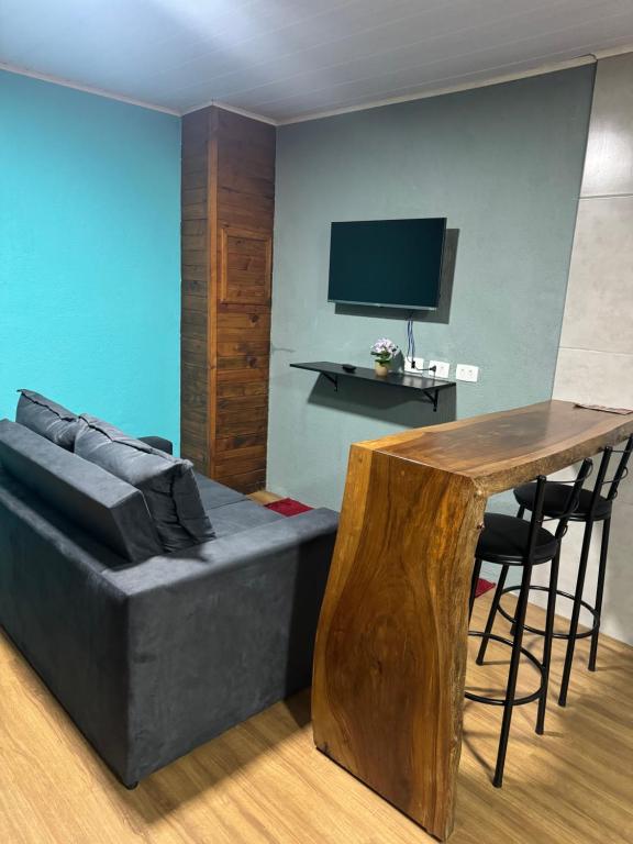 una sala de estar con un sofá y una mesa en Recanto da Bia, en Campos do Jordão