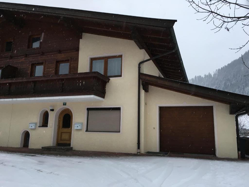 ein Haus mit Garage im Schnee in der Unterkunft Ferienwohnungen Wies in Söll