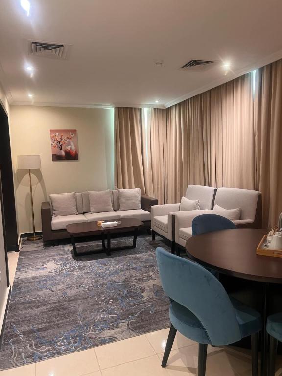 a living room with a couch and chairs and a table at AG Hotel in Abu Dhabi