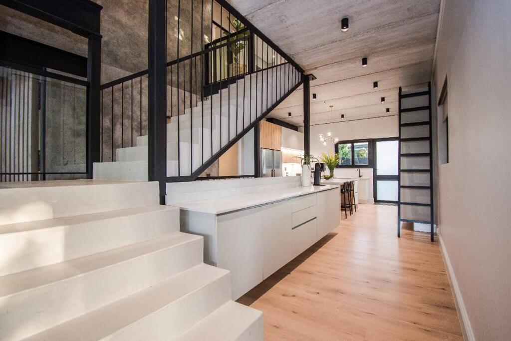 una scala in una casa con pareti bianche e pavimenti in legno di Modern House Dalsig Stellenbosch a Stellenbosch