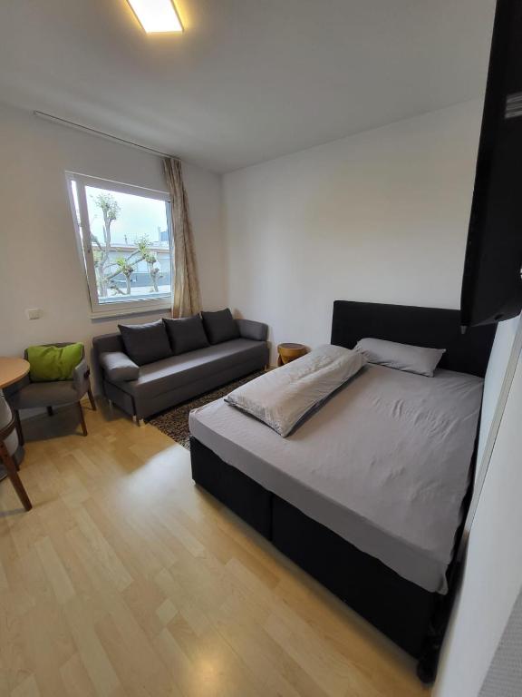 a small bedroom with a bed and a couch at Innenstadt Perle Euskirchen in Euskirchen