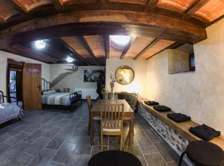 un salon avec une table et une chambre dans l'établissement Le refuge de la Panxa ¡Una experiencia mágica!, à Ur
