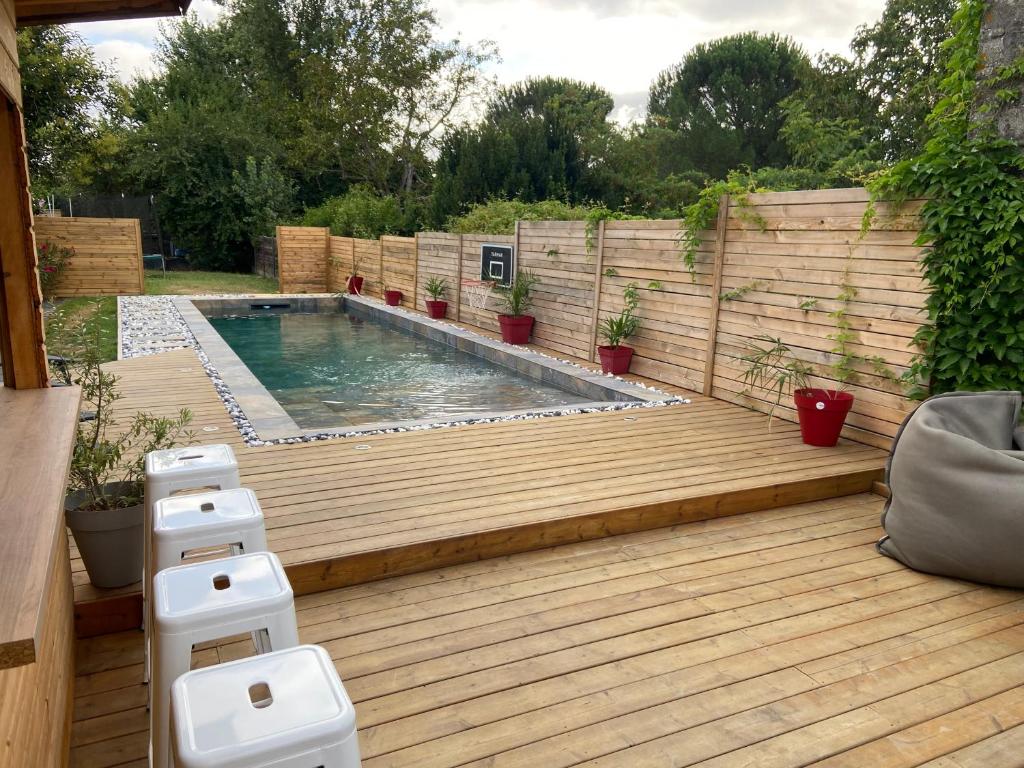 EstillacにあるMaison 4 Chambres avec Piscineの木製デッキ付きの裏庭のスイミングプール