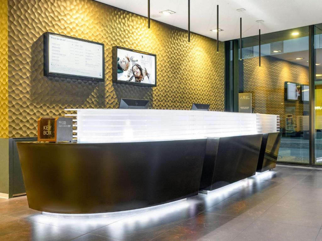 a lobby with a reception desk in a building at Novotel Lugano Paradiso in Lugano