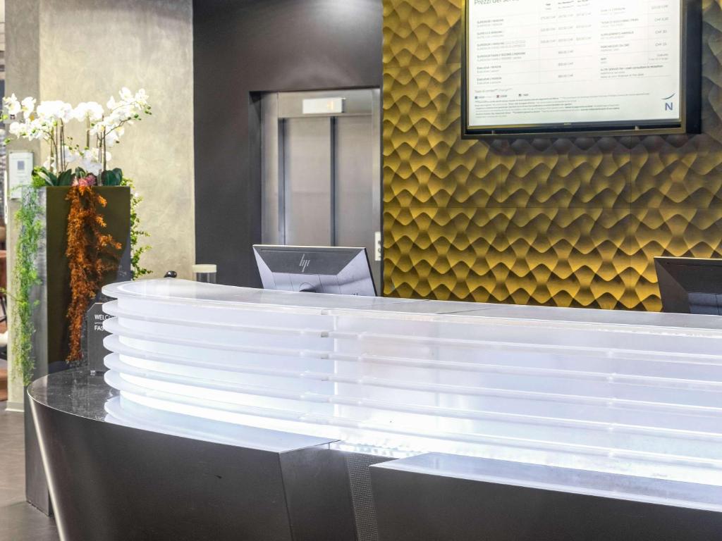 a counter in a restaurant with a yellow wall at Novotel Lugano Paradiso in Lugano