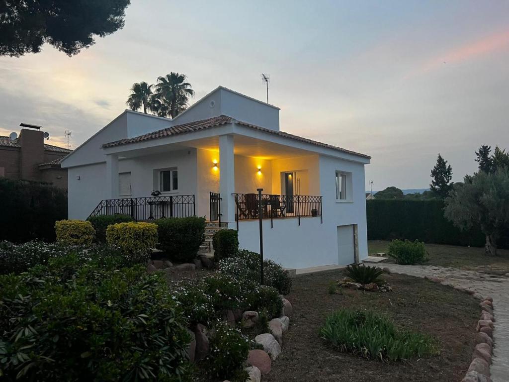 a white house with lights on in a yard at Acogedora casa con piscina in Lliria